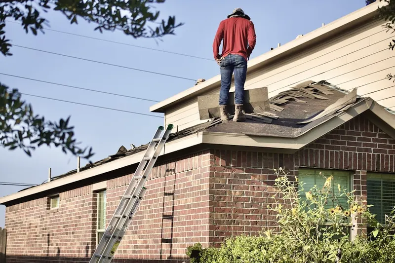 Professional roofer working on a residential roof in West Eaton